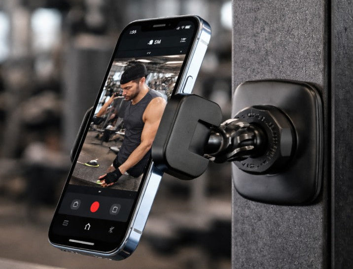 Smartphone mounted on a gym machine with a blurred gym background